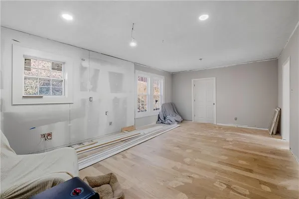 a view of an empty room with window and wooden floor