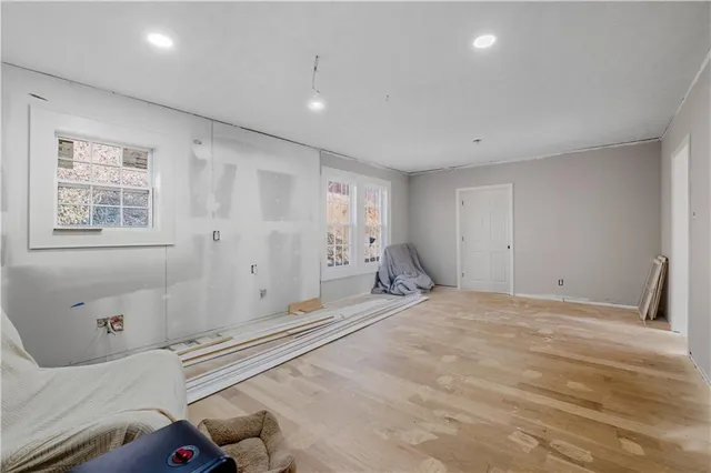 a view of an empty room with window and wooden floor