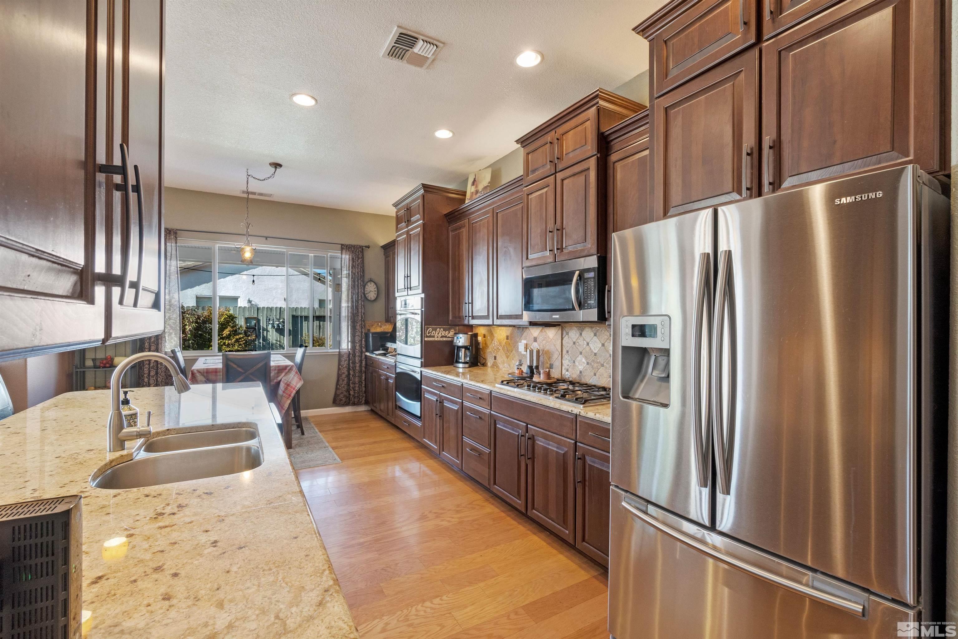 1301 Cranwood Court Reno, NV 89521 - Photo 16 of 34 a kitchen with stainless steel appliances granite countertop a refrigerator a sink and a stove