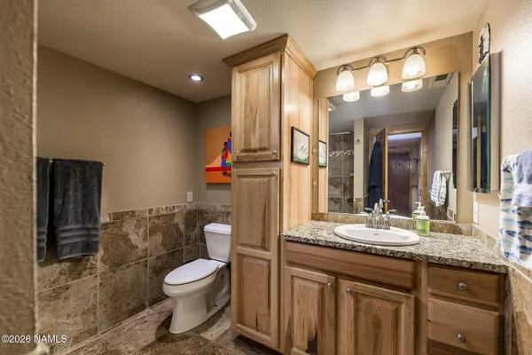 a bathroom with a granite countertop sink toilet and shower