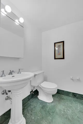 a bathroom with a sink a toilet and a mirror