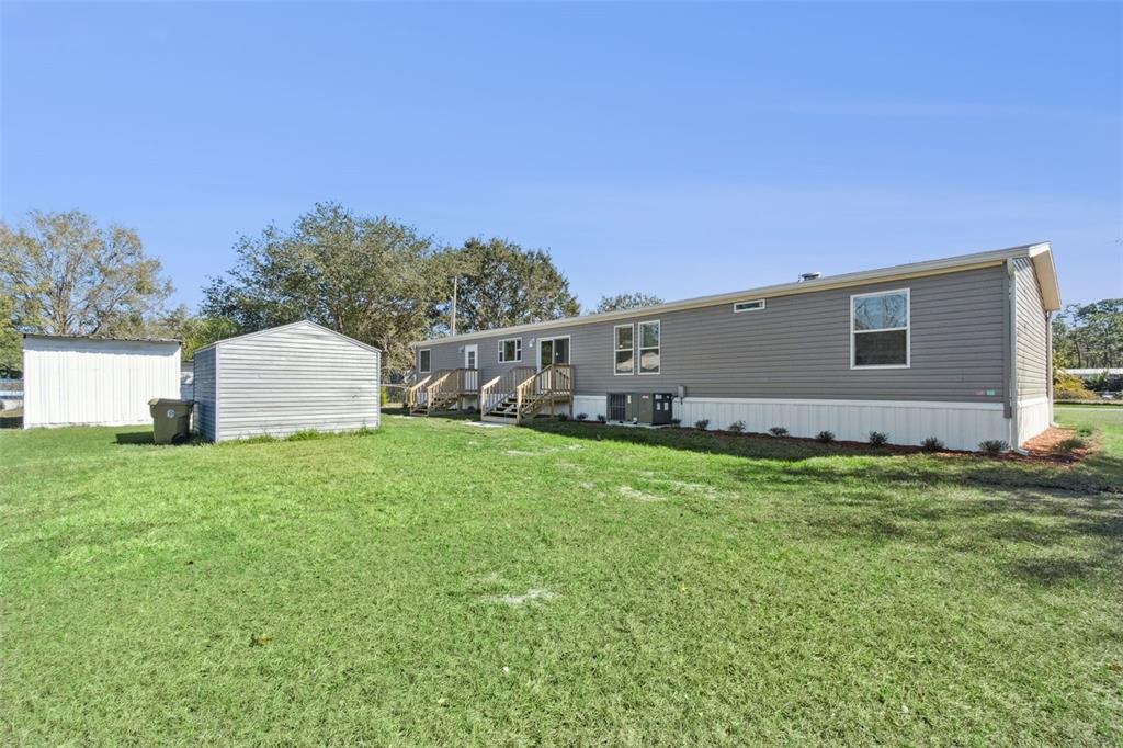 180 Sandpine Court St. Cloud, FL 34771 - Photo 28 of 28 a view of a backyard with plants and large trees
