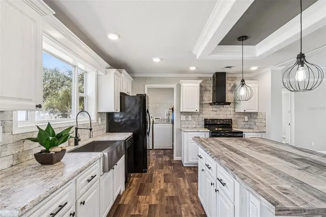 a kitchen with stainless steel appliances granite countertop a sink a stove and a refrigerator