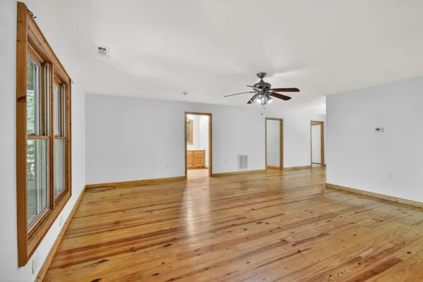 a view of a livingroom with a ceiling fan and window