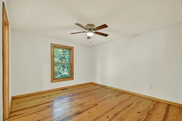 a view of a room with wooden floor and a ceiling fan
