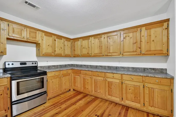 a kitchen with wooden cabinets and a stove top oven