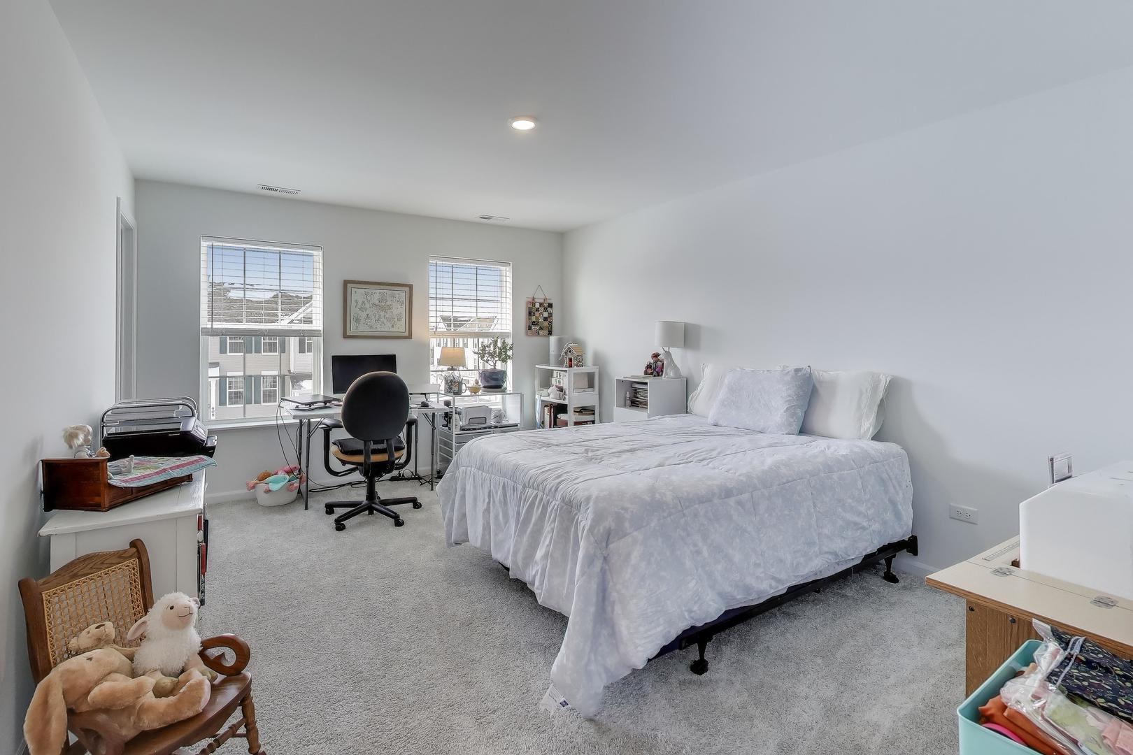 709 Neubauer Circle Lindenhurst, IL 60046 - Photo 12 of 25 a bedroom with a bed a chair and a fireplace