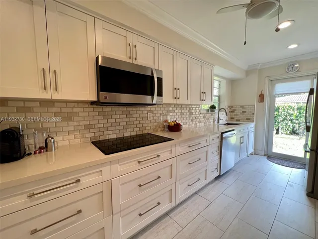 a kitchen with stainless steel appliances a sink dishwasher stove microwave and cabinets