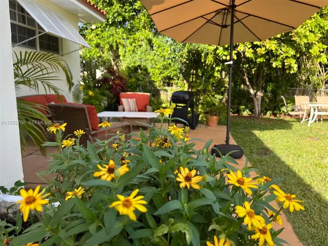 a view of a patio with table and chairs under an umbrella