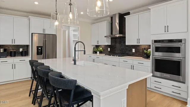 a large kitchen with granite countertop a large counter top a sink stainless steel appliances and cabinets