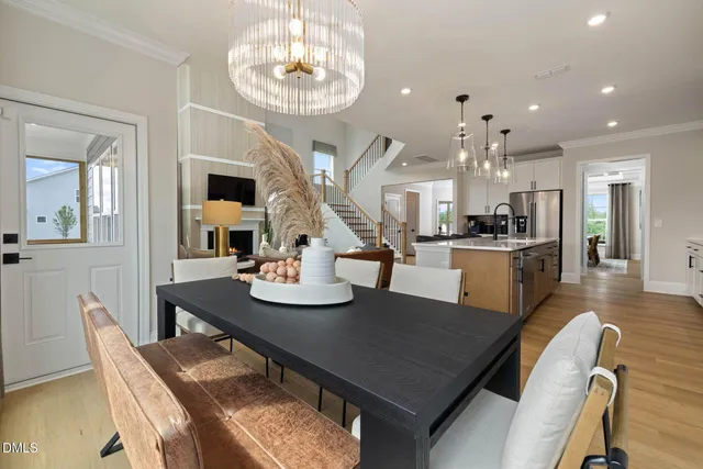 a kitchen with stainless steel appliances a kitchen island hardwood floor sink stove dining table and chairs