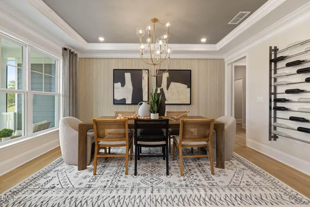 a view of a dining room with furniture a chandelier and wooden floor