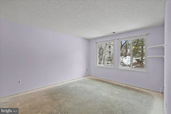 a view of a big room with windows and refrigerator