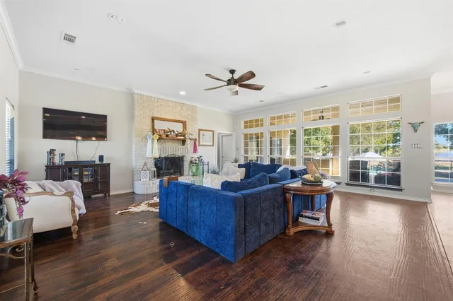 a living room with furniture kitchen view and a wooden floor