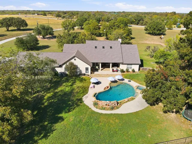 a aerial view of a house with pool and ocean view
