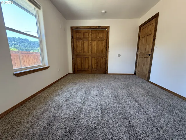 an empty room with a window and a fan