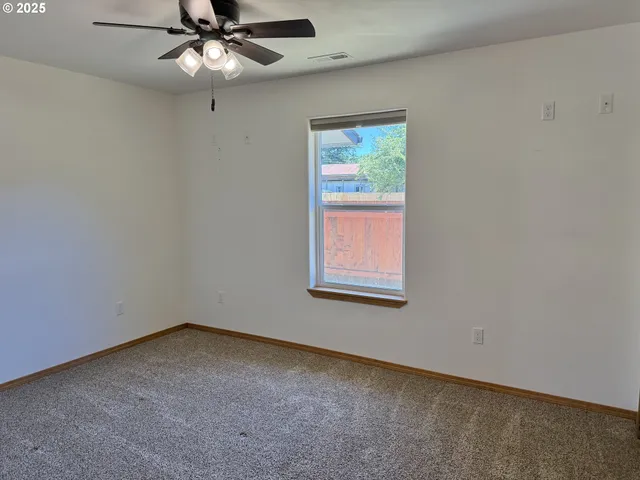 a view of a hallway with wooden floor and a large window