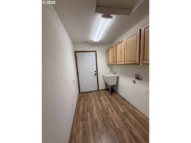 a view of a hallway with wooden floor and a large window