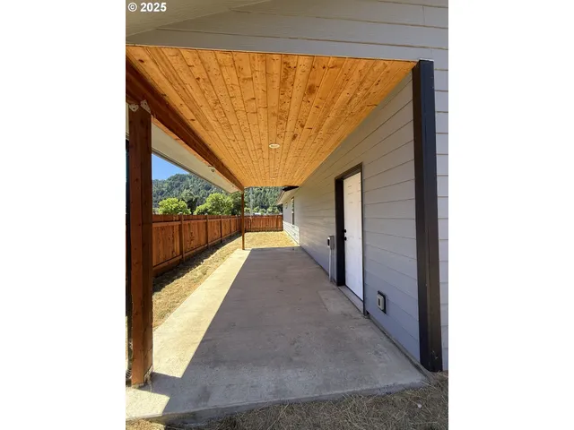 a spacious bedroom with a large window and chandelier