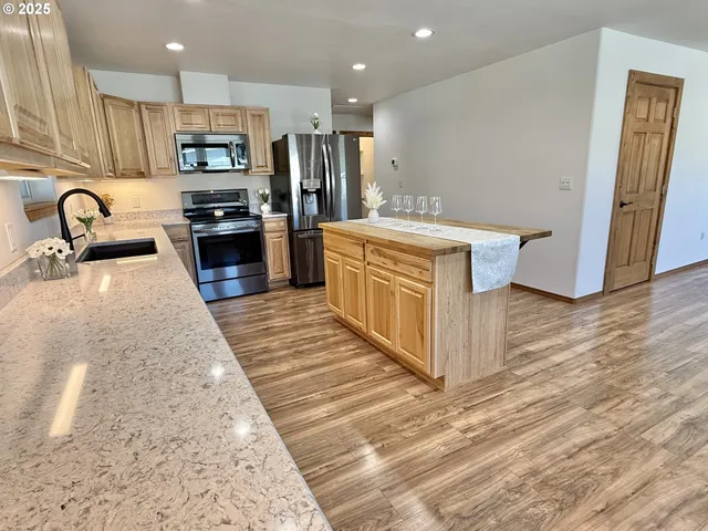 a kitchen with stainless steel appliances granite countertop a refrigerator and a stove top oven