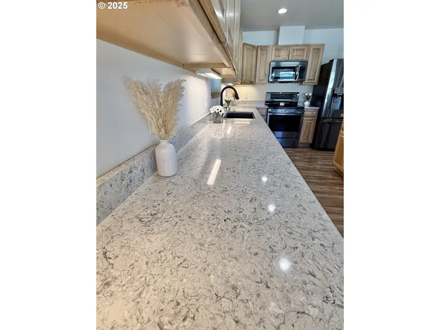 a kitchen with stainless steel appliances kitchen island granite countertop a stove top oven a sink and dishwasher