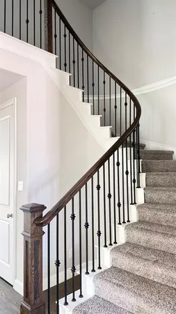 a view of staircase with railing and white walls