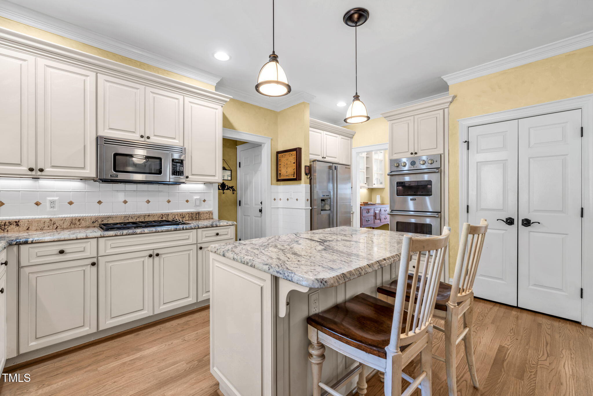 9009 Hometown Drive Raleigh, NC 27615 - Photo 16 of 82 a kitchen with stainless steel appliances granite countertop a stove top oven a refrigerator a sink and white cabinets with wooden floor