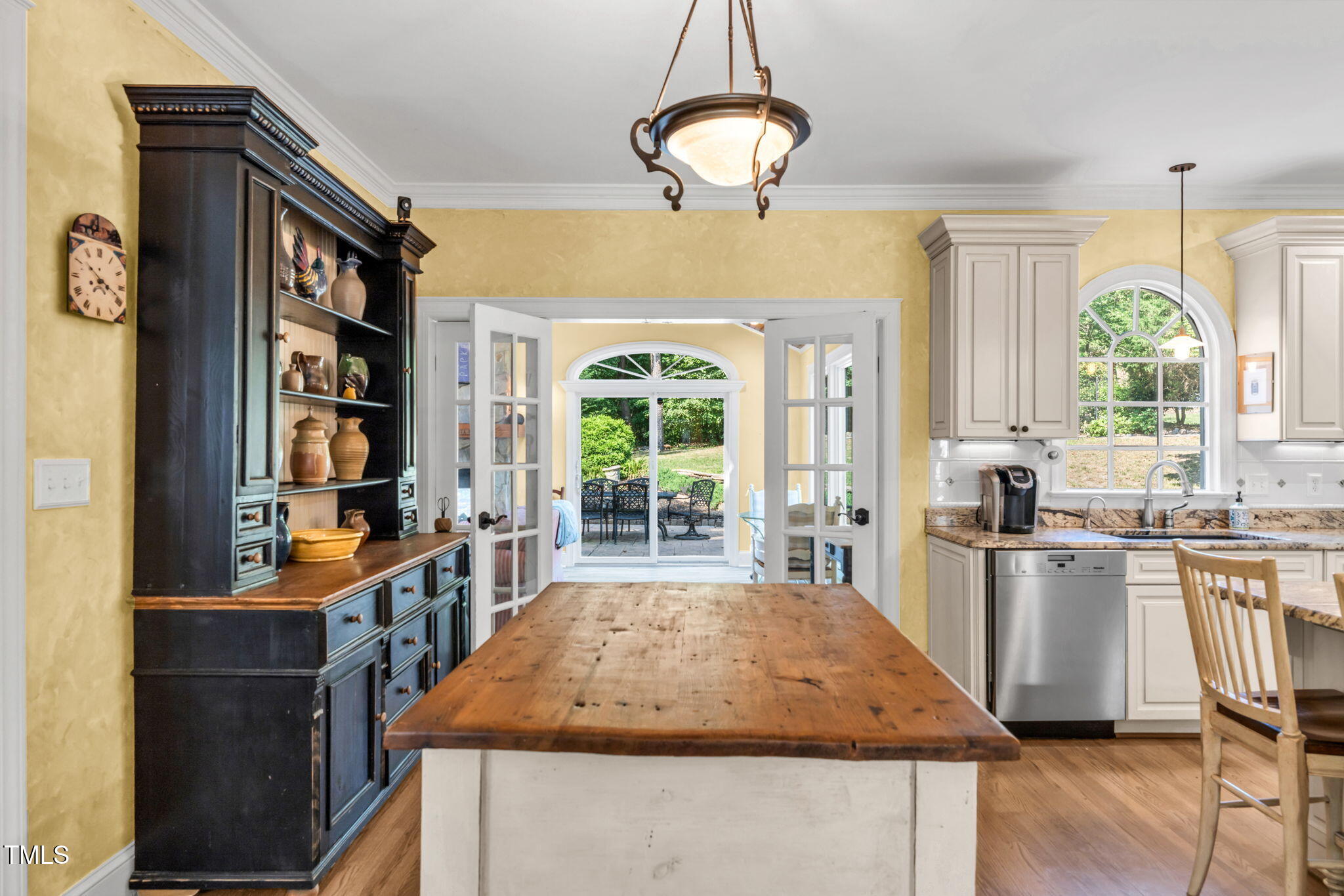 9009 Hometown Drive Raleigh, NC 27615 - Photo 20 of 82 a room with kitchen island granite countertop wooden floor and stainless steel appliances