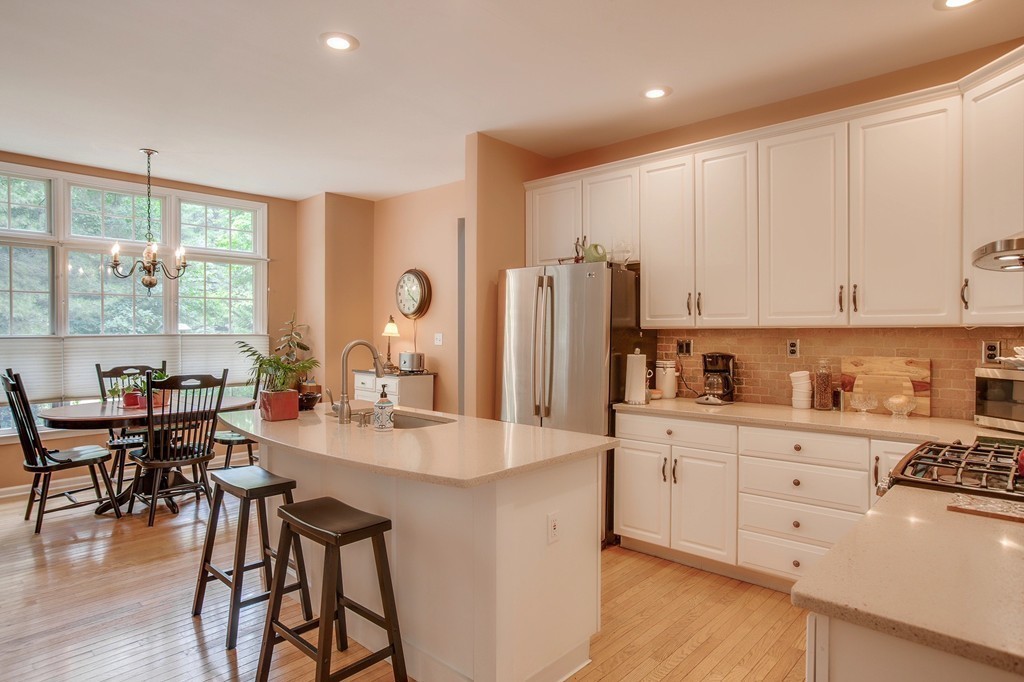 5 Emery Road, Unit 5 Bedford, MA 01730 - Photo 2 of 29 a kitchen with stainless steel appliances granite countertop a refrigerator a stove a sink dishwasher and white cabinets with wooden floor