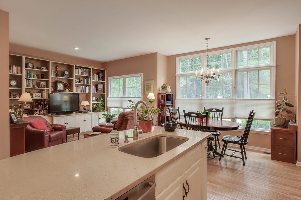 5 Emery Road, Unit 5 Bedford, MA 01730 - Photo 5 of 29 a kitchen with a stove a sink a dining table and chairs
