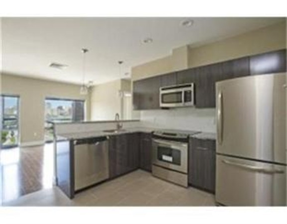 a kitchen with stainless steel appliances granite countertop a refrigerator a stove a sink and a refrigerator