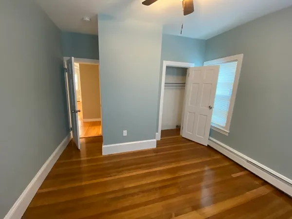 an empty room with wooden floor and door