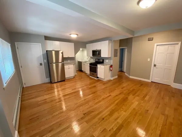 a view of a kitchen with refrigerator microwave and wooden floor