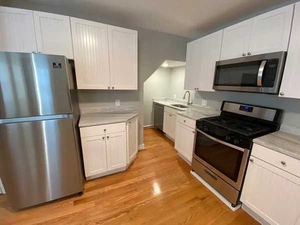 a kitchen with appliances a sink and a refrigerator
