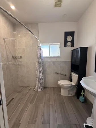 a bathroom with a toilet and a shower