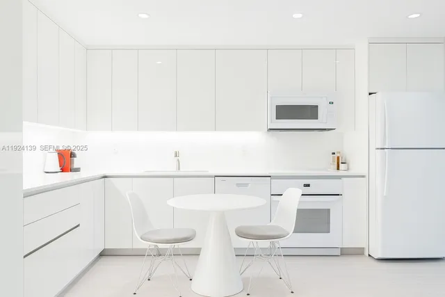 a kitchen with a sink a stove and white cabinets