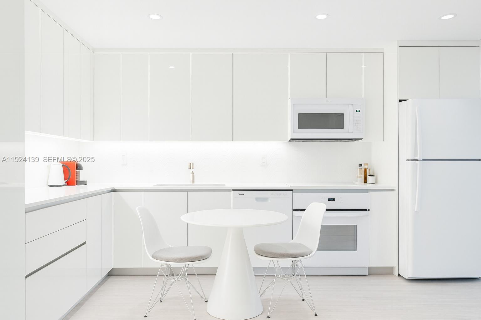a kitchen with a sink a stove and white cabinets