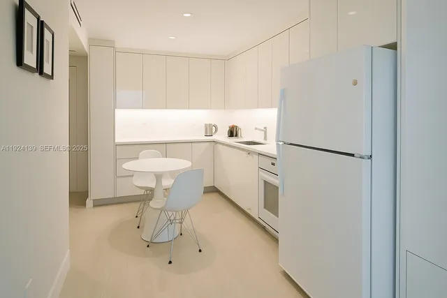 a kitchen with white cabinets and white appliances