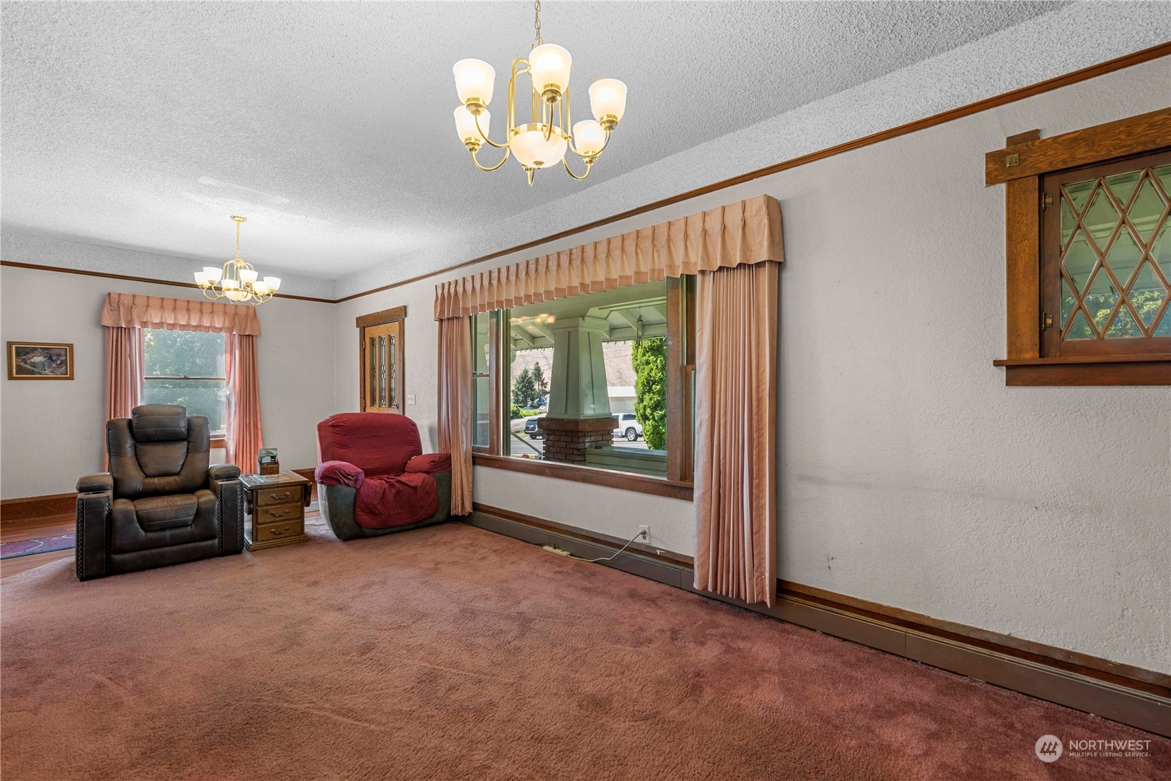 3327 Crestview Road Wenatchee, WA 98801 - Photo 9 of 39 a living room with furniture a chandelier and a flat tv screen