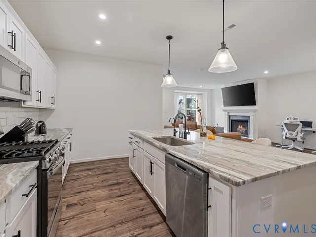 a kitchen with sink stove and wooden floor