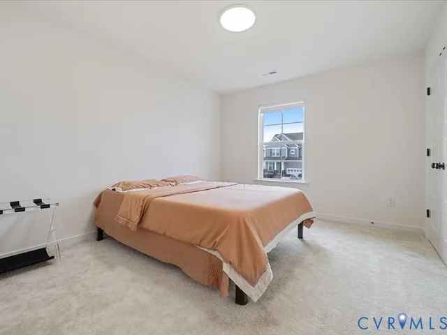 a spacious bedroom with a bed and a window