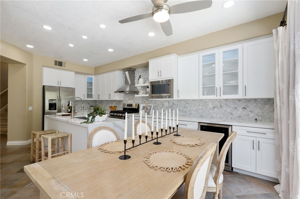 73 Blazewood Lake Forest, CA 92610 - Photo 12 of 53 a kitchen with stainless steel appliances granite countertop a sink a stove a refrigerator a microwave oven with a dining table and chairs