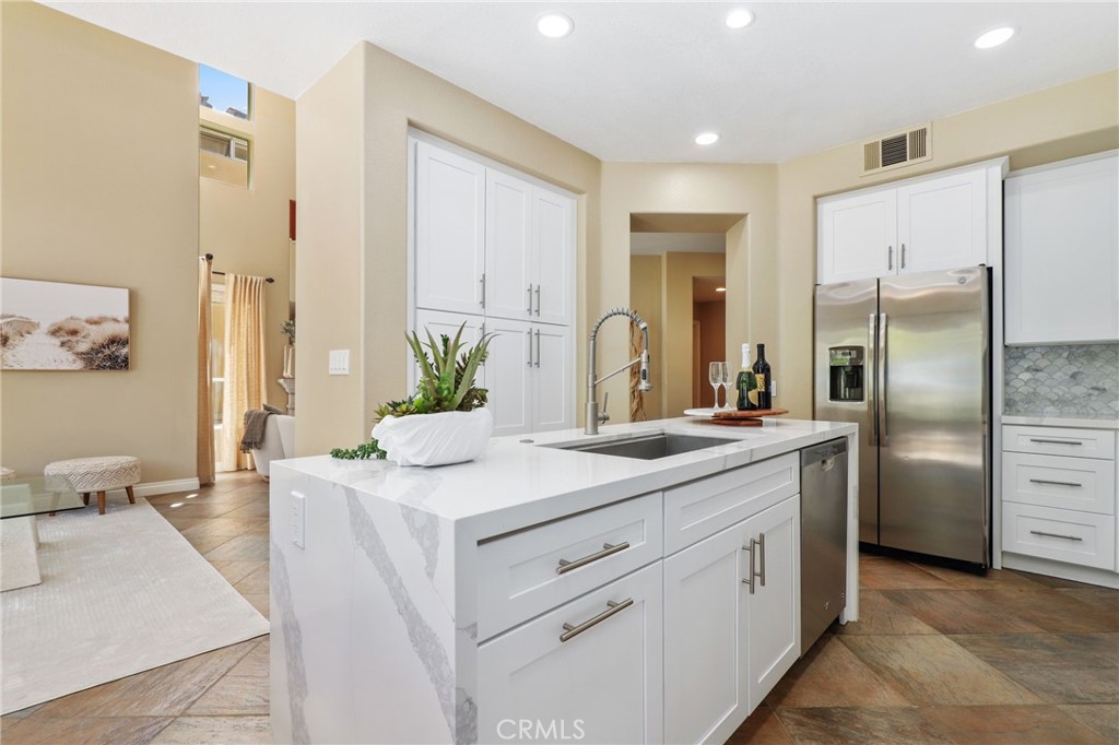 73 Blazewood Lake Forest, CA 92610 - Photo 16 of 53 a kitchen with white cabinets and stainless steel appliances