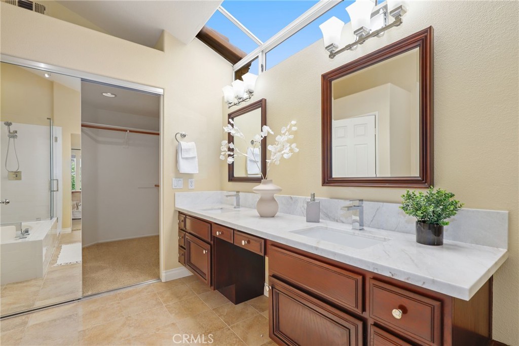 73 Blazewood Lake Forest, CA 92610 - Photo 27 of 53 a bathroom with a granite countertop sink a large mirror and a shower