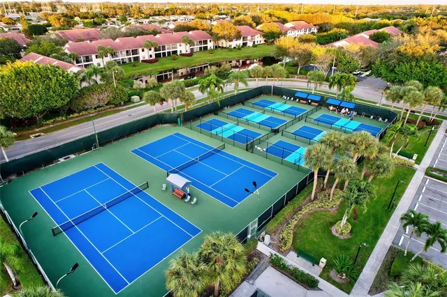 an aerial view of a tennis ground and a cars park