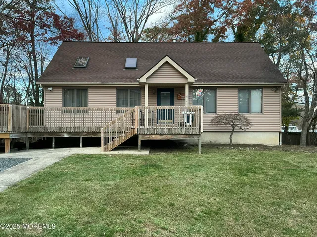 a view of a house with a yard and a large tree