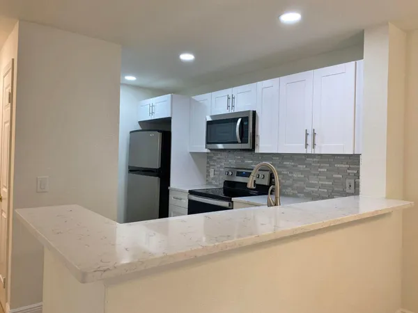 a kitchen with granite countertop a refrigerator and a sink