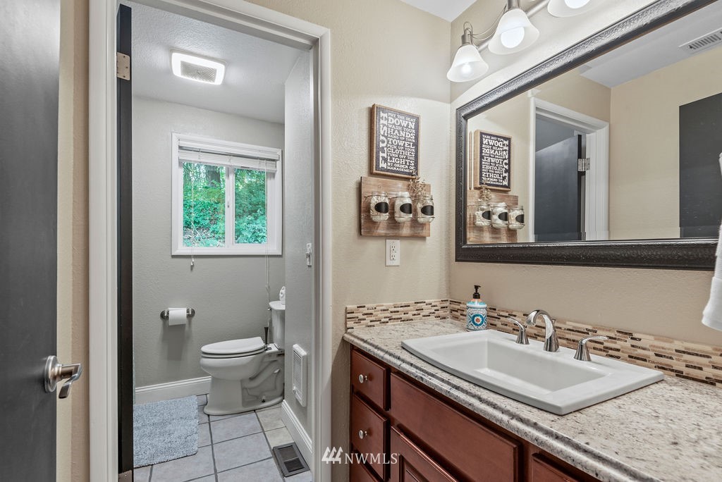 755 Hazel Dell Road Castle Rock, WA 98611 - Photo 14 of 30 a bathroom with a granite countertop sink a toilet and a mirror