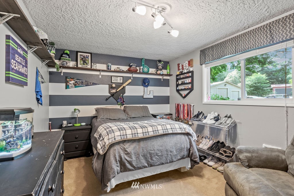 755 Hazel Dell Road Castle Rock, WA 98611 - Photo 15 of 30 a bedroom with a bed a bookshelf and a large window