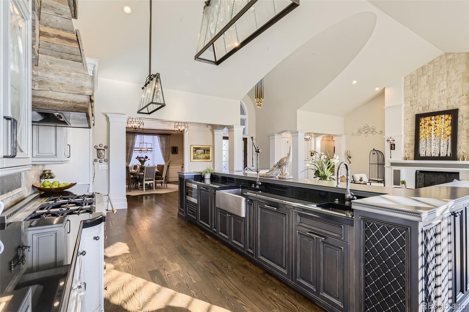 1050 Buffalo Ridge Road Castle Pines, CO 80108 - Photo 11 of 50 a kitchen with kitchen island granite countertop a sink a counter space appliances and cabinets